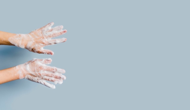 Бесплатное фото Вид спереди рук с пеной из мыла и копией пространства