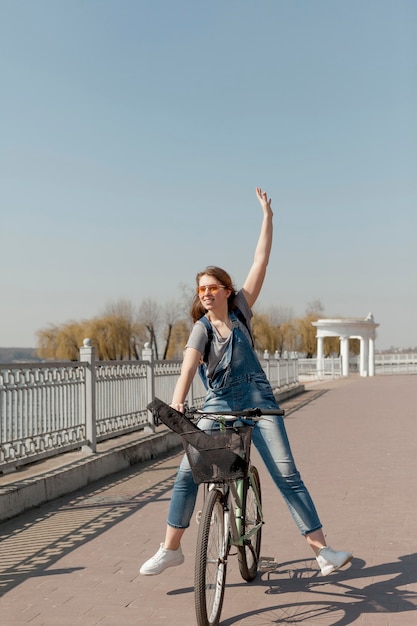 Бесплатное фото Вид спереди беззаботной женщины на велосипеде