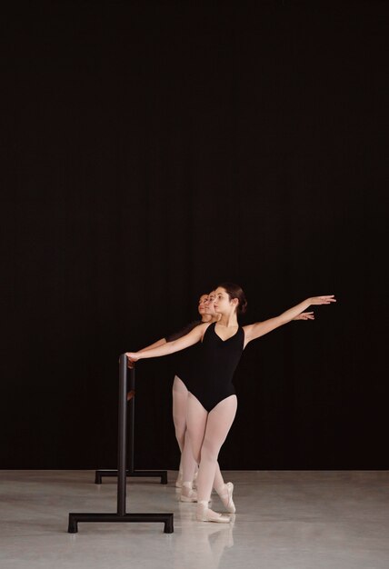 Бесплатное фото Вид спереди профессиональных балерин, репетирующих вместе с копией пространства