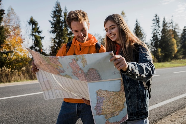 Бесплатное фото Смайлик пара консультируется с картой во время поездки