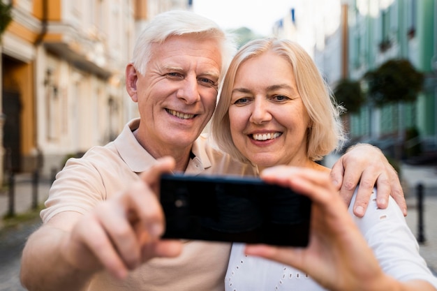 無料写真 屋外、selfieを取ってスマイリーシニアカップルの正面図