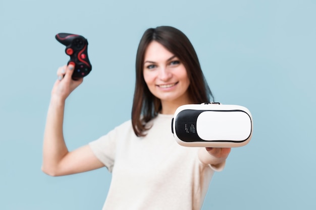 Бесплатное фото Вид спереди смайлик женщина, держащая гарнитура виртуальной реальности