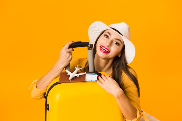 Бесплатное фото Вид спереди женщины, позирующей с багажом и предметами первой необходимости