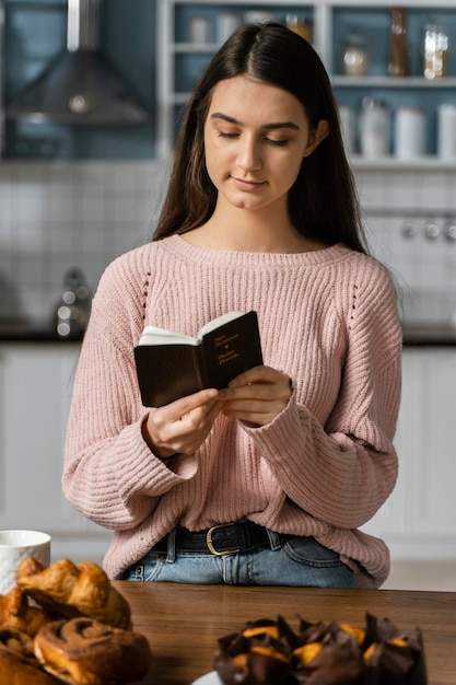 Бесплатное фото Вид спереди женщины, молящейся с библией