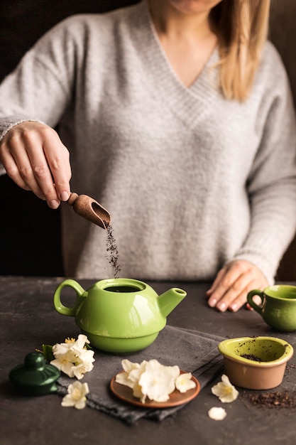 Бесплатное фото Вид спереди женщины готовит чай концепции