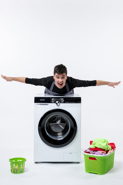 無料写真 白い壁に洗濯機と汚れた服を着た若い男性の正面図
