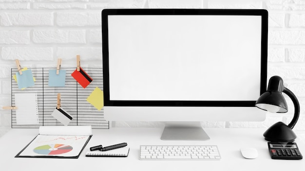 Front view of office desk with computer and lamp