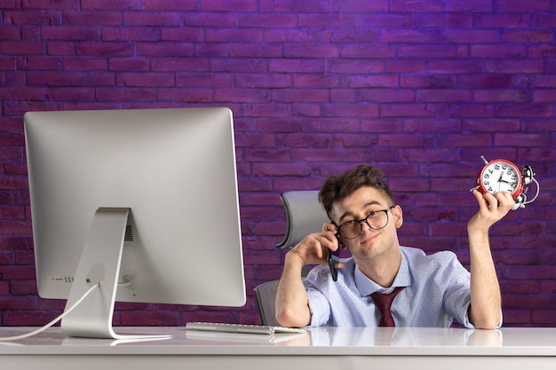 Front view office worker behind office desk talking