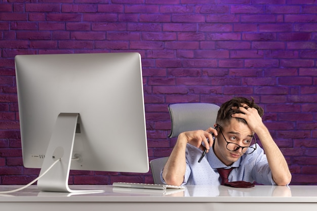 Free photo front view office worker behind office desk talking