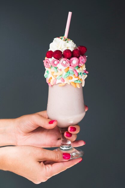 Front view oh hands holding glass of milkshake