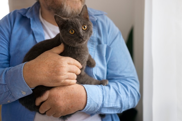 Front view old man holding cat