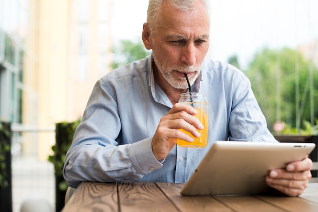 Free photo front view old man looking at a tablet