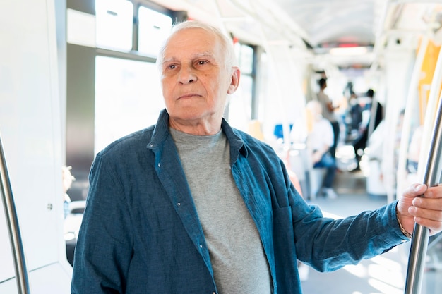 Vista frontale dell'uomo anziano nel trasporto pubblico
