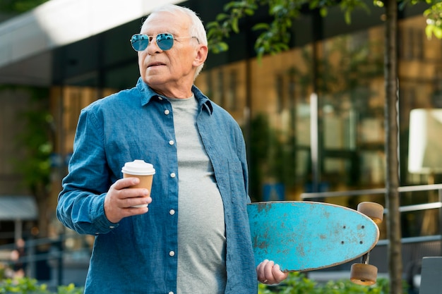 Free photo front view of old man with skateboard