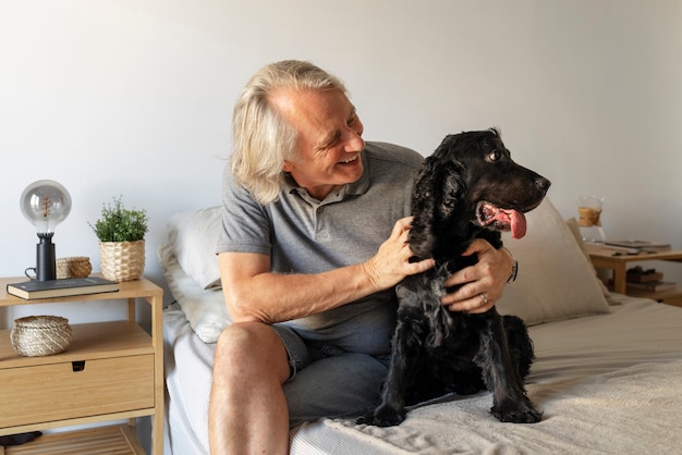 Front view old smiley man petting dog