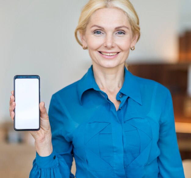 Front view of older business woman holding smartphone