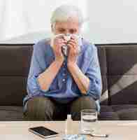 Free photo front view of older woman blowing her nose