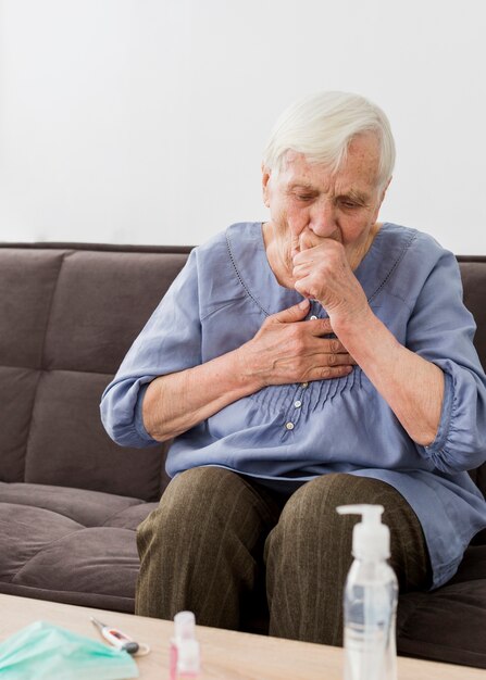 Front view of older woman coughing