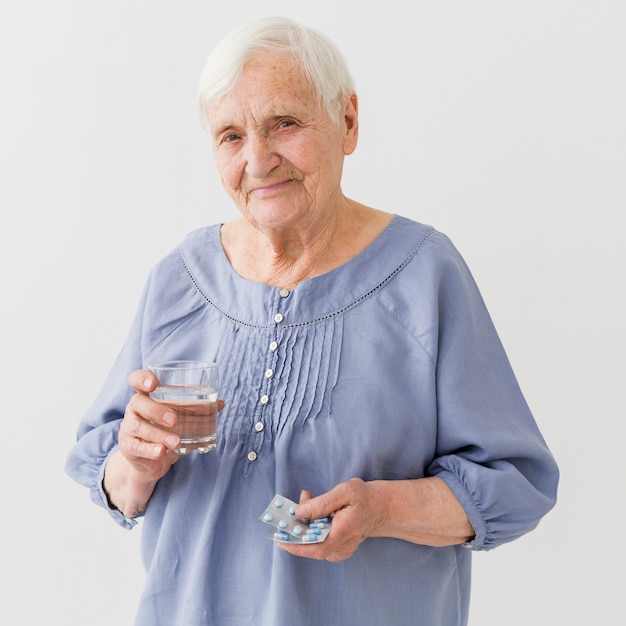 Front view of older woman holding her pills