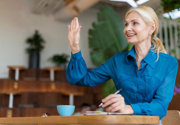 Front view of older woman ordering something while working