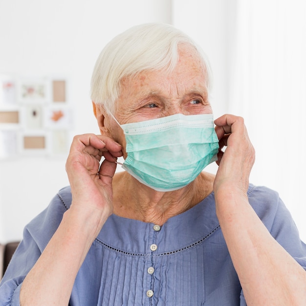 Front view of older woman posing with medical mask
