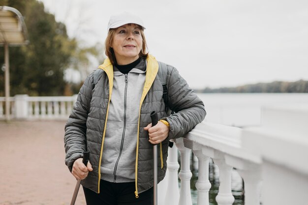 Front view of older woman with trekking sticks