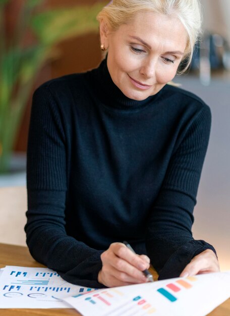 Front view of older woman working with papers and pen