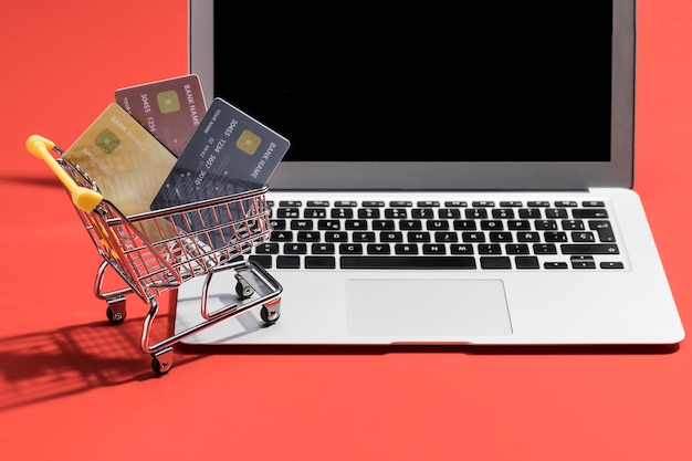 A small shopping cart carrying three credit cards