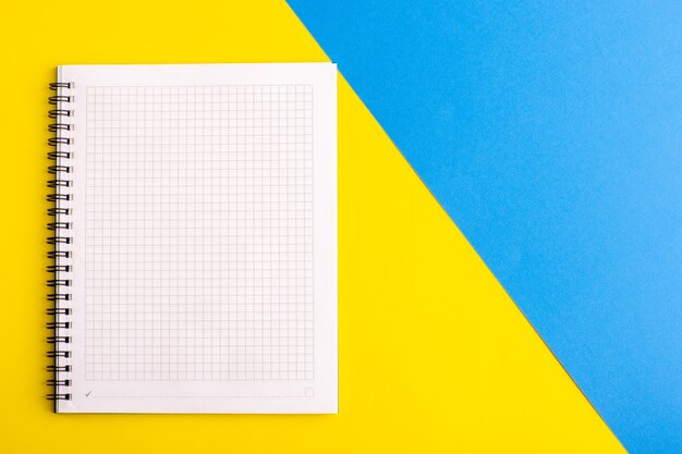 Front view open blue copybook blank paper on yellow-blue surface