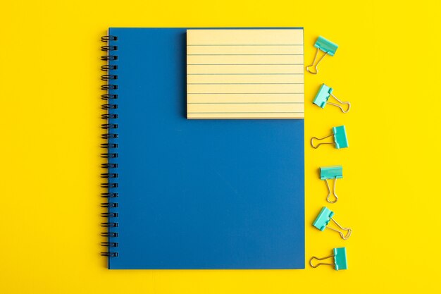 Front view open blue copybook on yellow desk