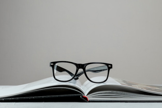 Вид спереди открытая книга в очках