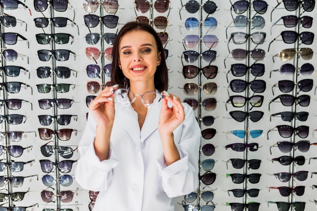 Front view of optician holding eyeglasses frame