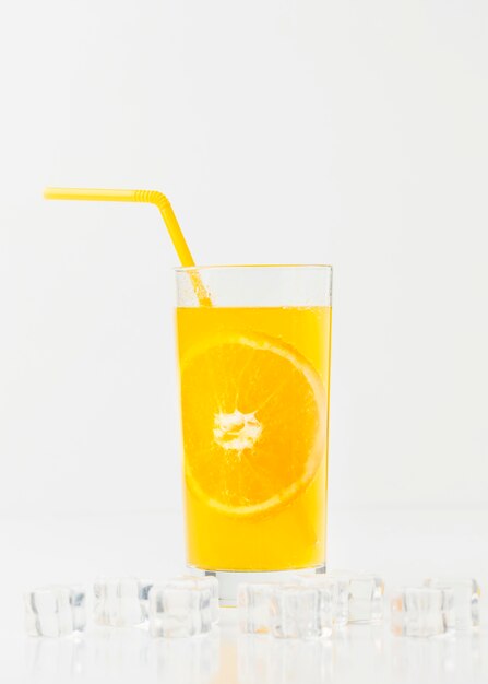 Front view of orange juice glass with straw