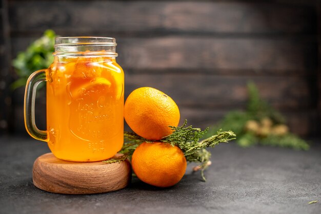 Front view orange lemonade in glass on wood board fresh oranges on brown isolated surface