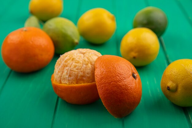 Апельсин вид спереди с очищенной кожурой на зеленом фоне
