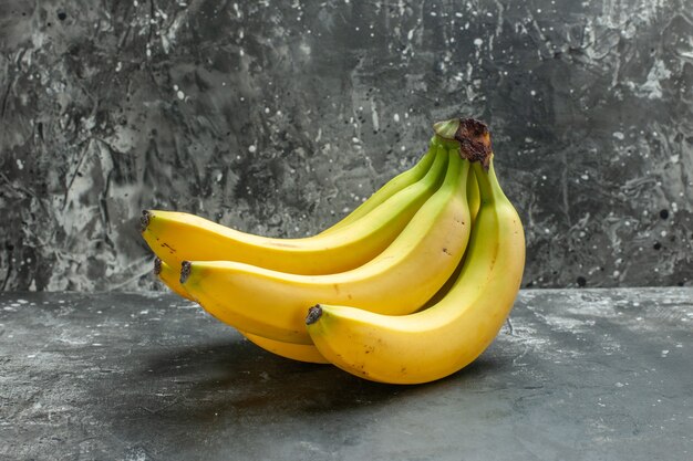 暗い背景に有機栄養源の新鮮なバナナの束の正面図
