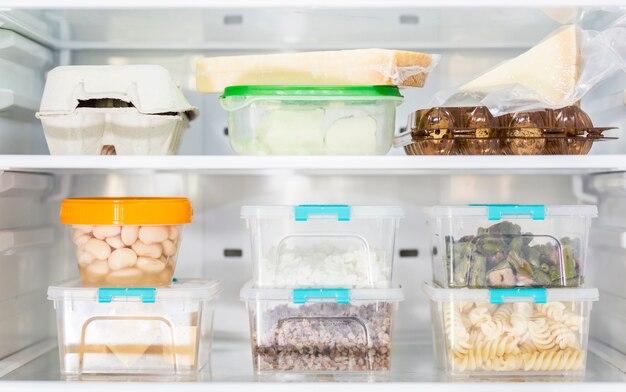 Front view of organized plastic food containers in fridge