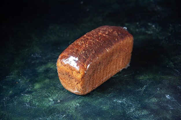 Front view of packed black bread on blue and black mixed colors background with free space