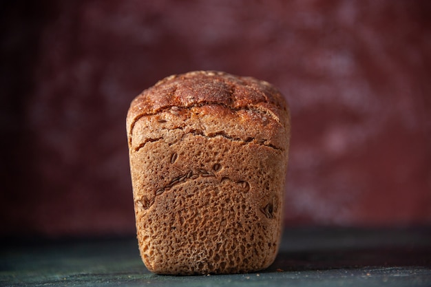 Front view of packed black bread on maroon distressed background with free space