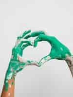 Free photo front view of painted hands making heart