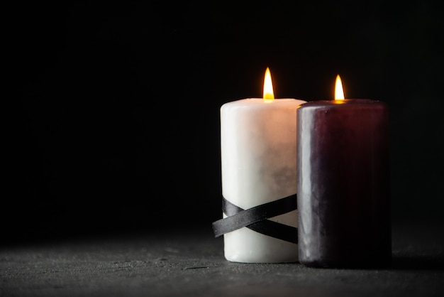 Free photo front view of pair of candles on black