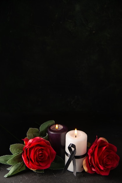 Front view of pair of candles red flowers on black