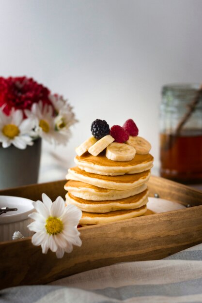 Front view pancake tower with banana and raspberries