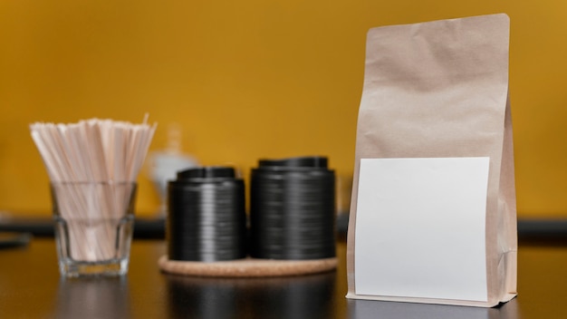 Foto gratuita vista frontale del sacchetto di caffè di carta sul bancone della caffetteria