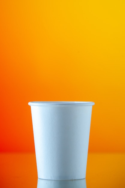 Front view paper water cup on orange wall