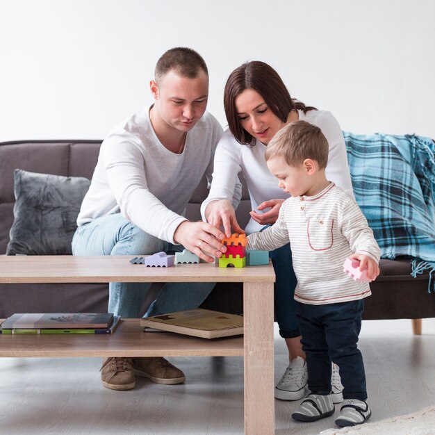 Front view of parents playing with child at home