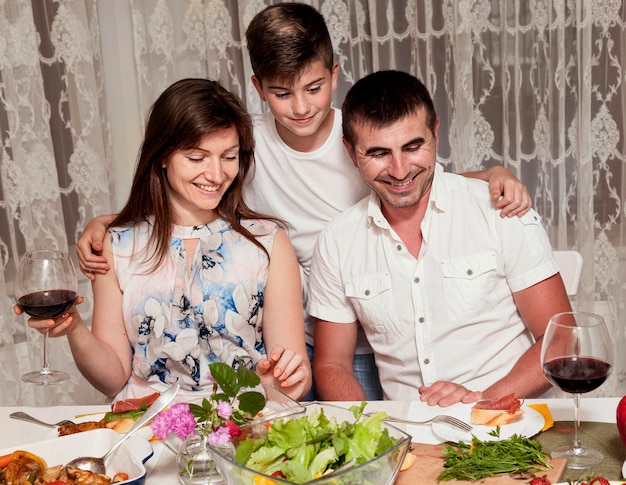 Front view of parents with son at dinner table