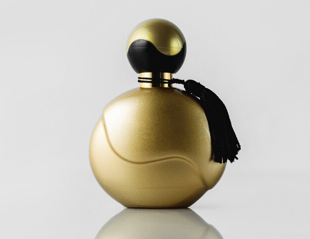 A front view parfume gold colored designed beautiful formed on the light wall