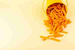 Free photo a front view pasta inside basket formed orange raw inside yellow basket on the cream background meal food pasta