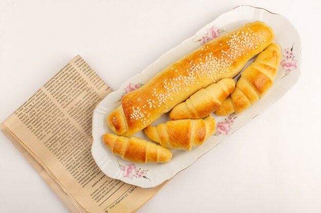 front view pastry and croissants brown cooked yummy inside white glass plate on the white floor